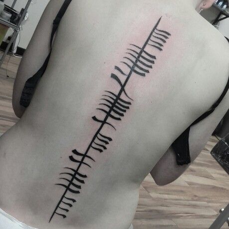 Large ogham tattoo on back with girl’s name “Seosaimhín” in Irish Gaelic