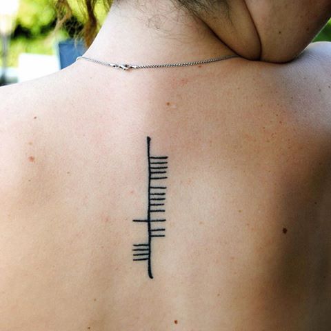 Another ogham tattoo on the upper back “clann”